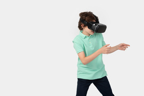 Niño con casco de realidad virtual sosteniendo algo