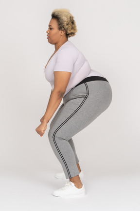 Tamanho plus size feminino flexionando joelhos de perfil