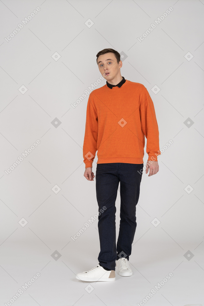 Jeune homme en sweat-shirt orange marchant