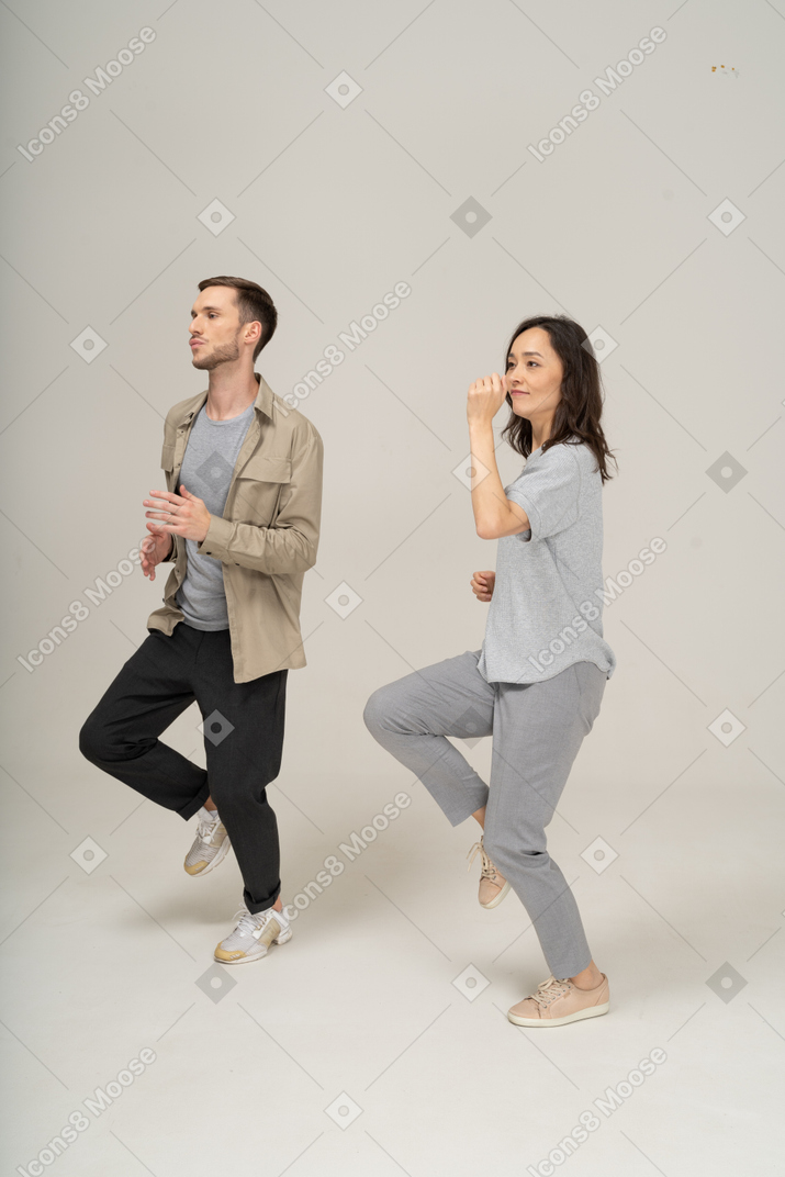 Side view of man and woman running and swinging their arms