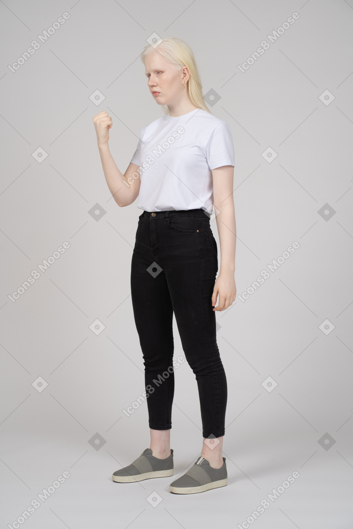 Young girl standing sideways with fist