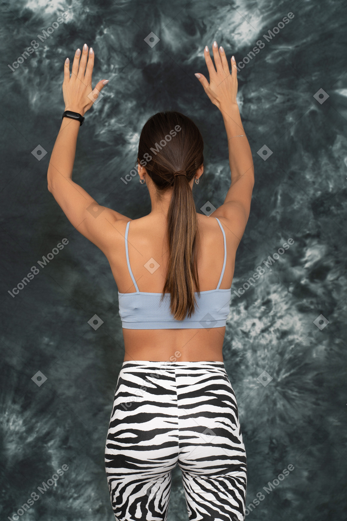 Back view of a female athlete raising her hands