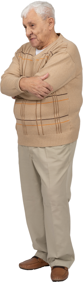 Vue de face d'un vieil homme heureux dans des vêtements décontractés debout avec les bras croisés