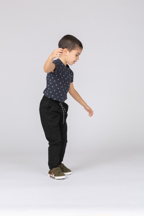 Vista lateral de um lindo menino dançando