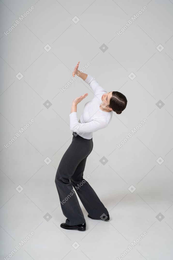 Vista lateral de uma mulher de terno dançando