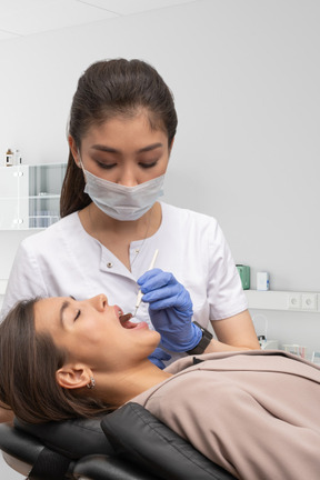 Mujer teniendo sus dientes revisados por dentista