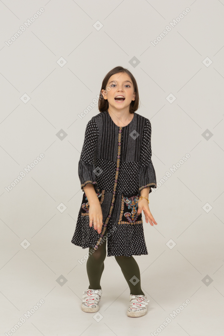 Front view of a talking little girl in dress looking at camera