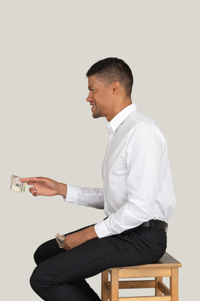 Hombre sonriente ofreciendo dinero