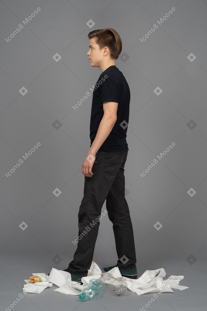 Male model walking left among garbage