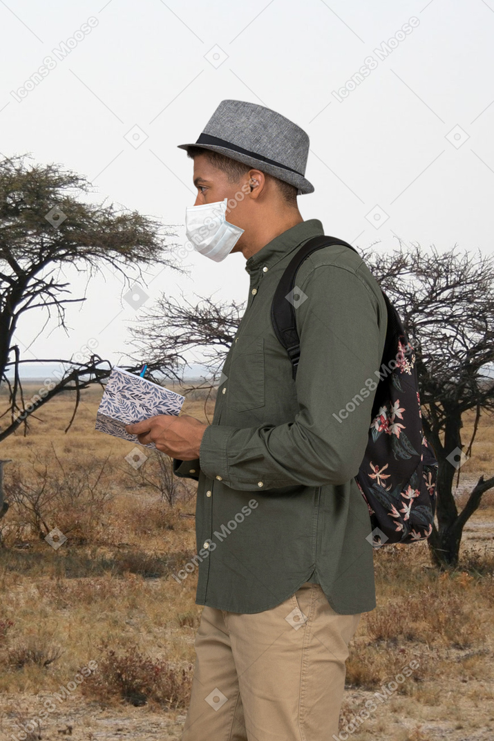 A man wearing a face mask standing in a field