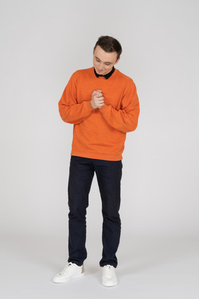 Joven en sudadera naranja de pie