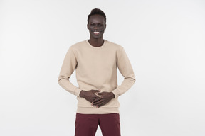 A young black man in a grey sweater standing alone on the white background