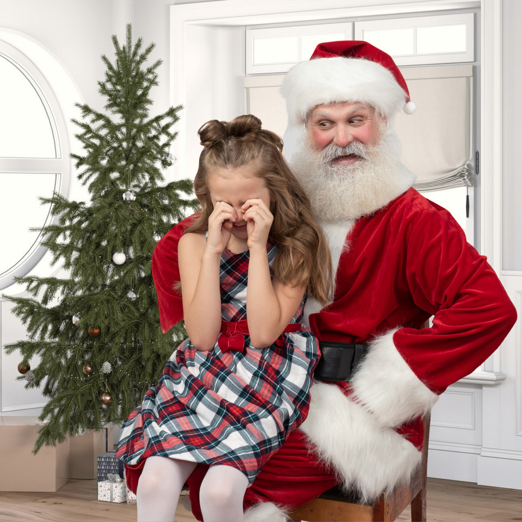 Santa claus holding wheeping girl