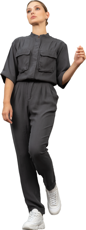 Front view of a walking young woman in a jumpsuit