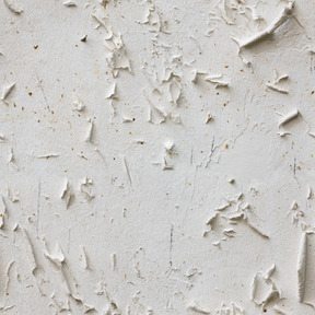 Ancienne couche de peinture fissurée sur mur de béton