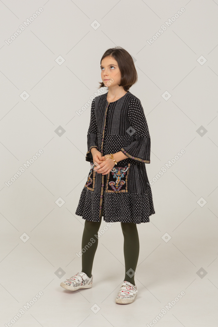 Vista de tres cuartos de una niña pensativa en vestido tomados de la mano juntos