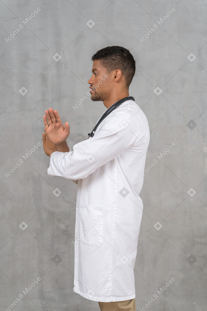 Side view of a male doctor showing stop sign