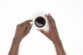 Schwarze männliche hände, die tasse schwarzen kaffee halten