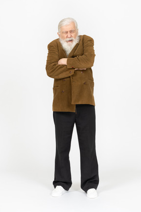 Elderly man with arms crossed, looking grumpy