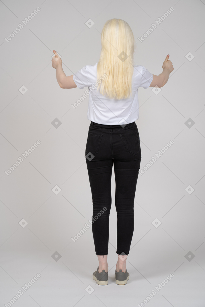 Blonde girl standing back to camera with two thumbs up