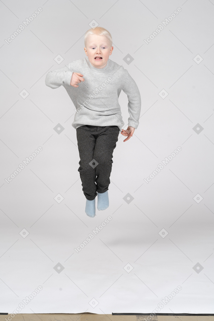 一个男孩跳得很高的前视图