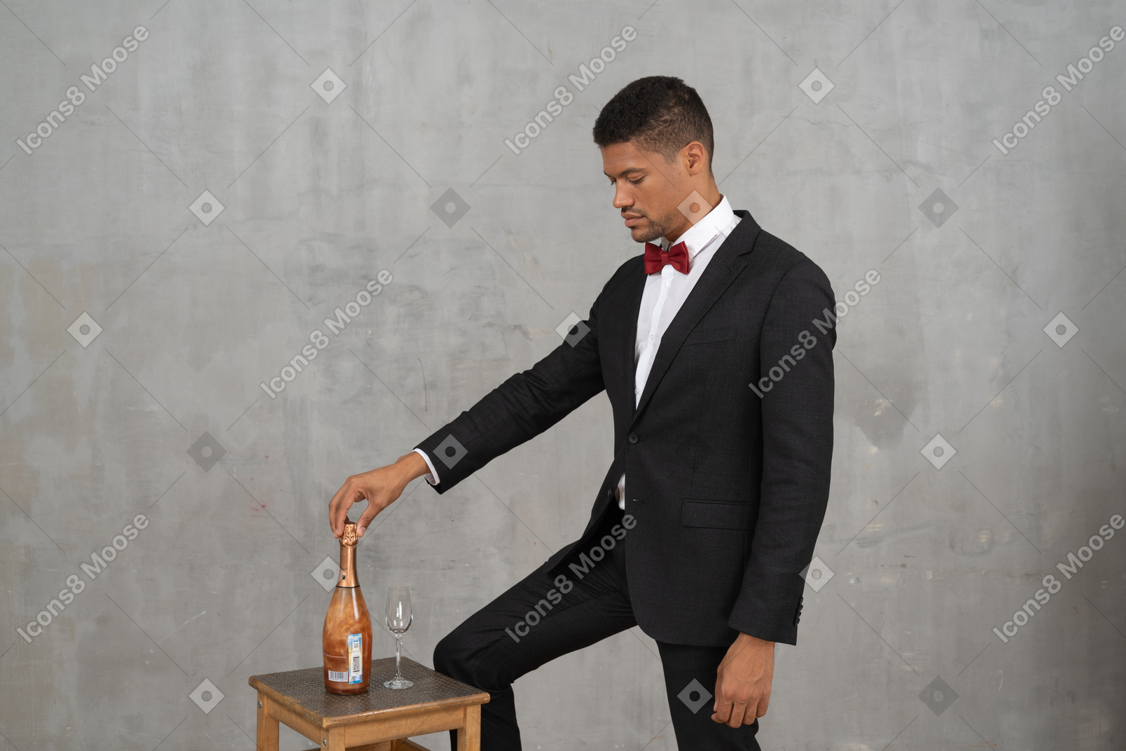 Man standing and looking down at a champagne bottle