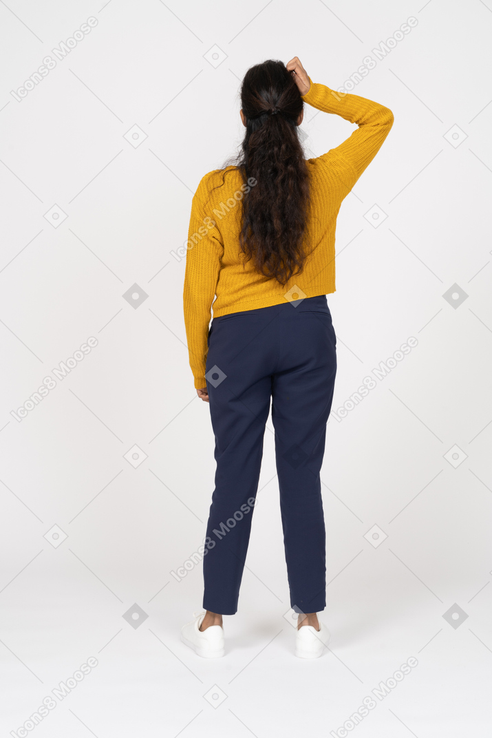 Vista posteriore di una ragazza in abiti casual in posa con la mano sulla testa