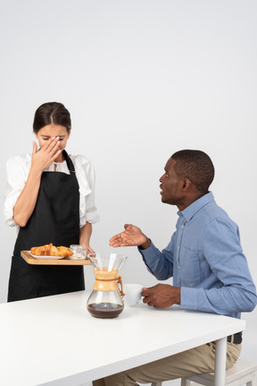 Disgruntled customer telling a waitress off for messing up his order