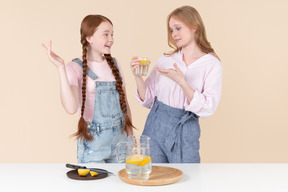 Two young girls drinking lemon water