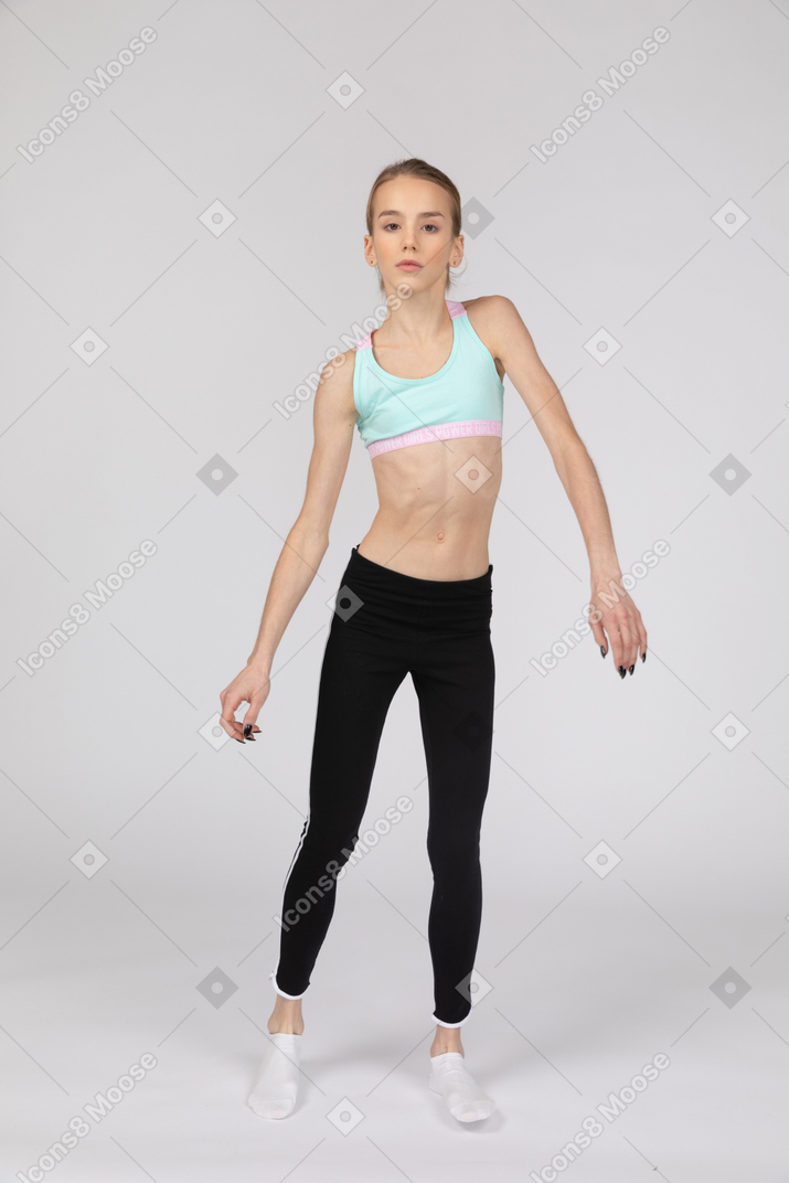 Vista frontale di una ragazza adolescente in abiti sportivi inclinando le spalle