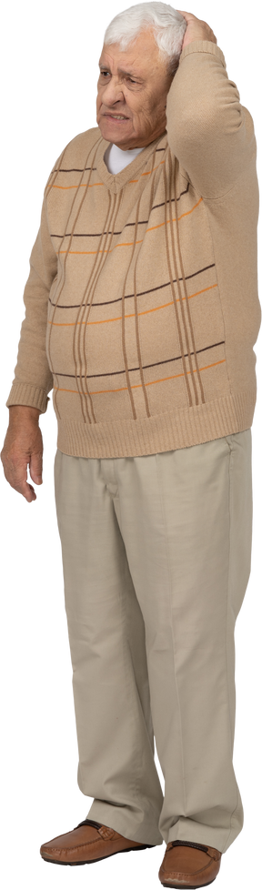 Vista frontal de um velho em roupas casuais em pé com a mão na cabeça