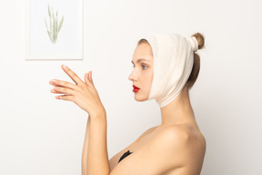 Vue latérale d'une femme avec un bandage de tête tenant les mains ensemble