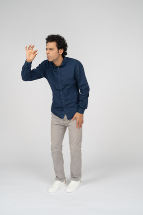 Vista frontal de un hombre en ropa casual que muestra el tamaño de algo