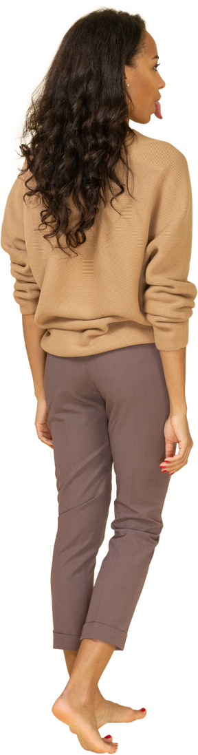 Vista traseira de uma jovem mulher com roupas casuais, mostrando a língua