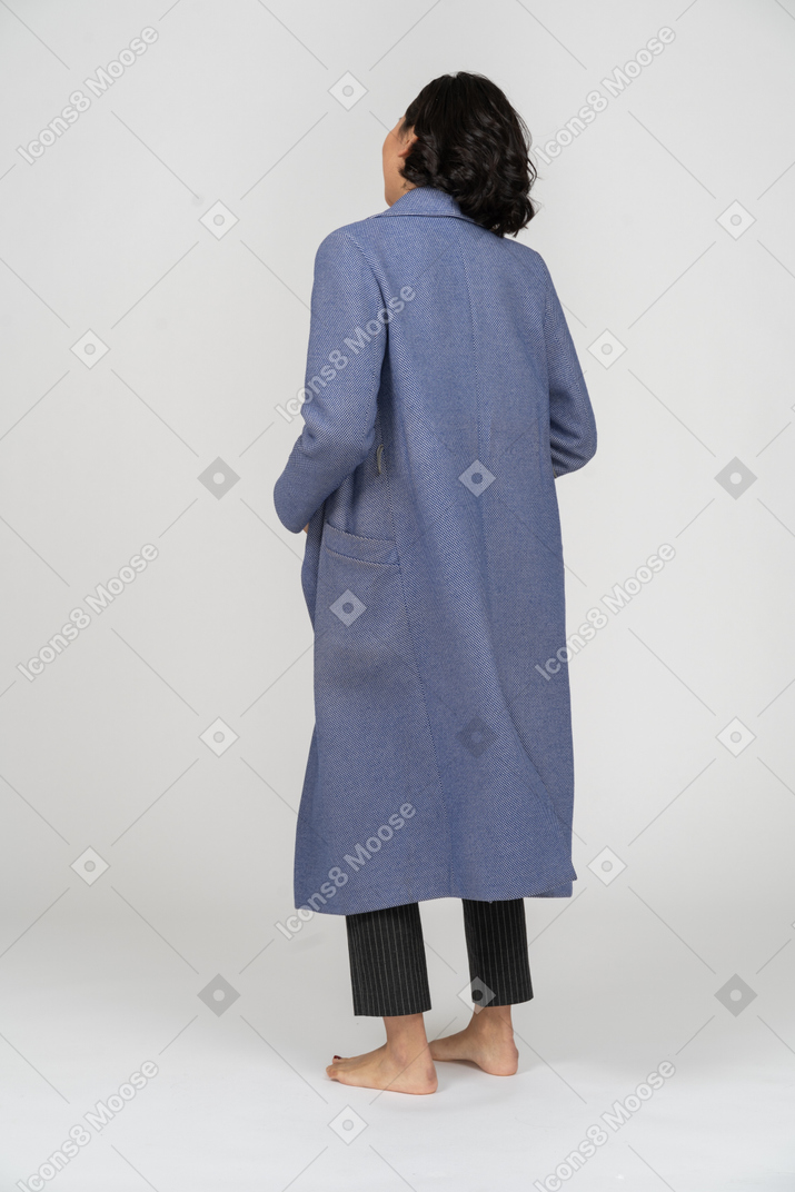 Вид сзади на женщину в синем пальто
