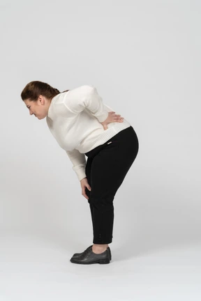 Plump woman in casual clothes suffering from pain in lower back