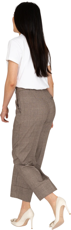Three-quarter back view of a running young lady in breeches and t-shirt
