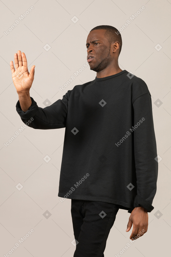 Man frowning and showing stop gesture with palm