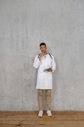 Medico maschio in piedi sullo sfondo
