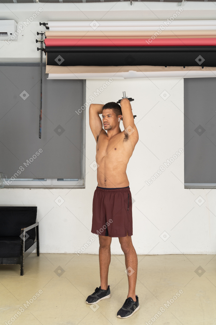 Athletic man exercising with dumbbell