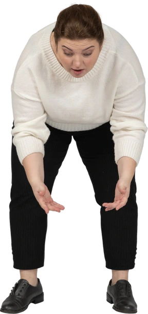 Front view of a plus size woman in casual clothes bending down