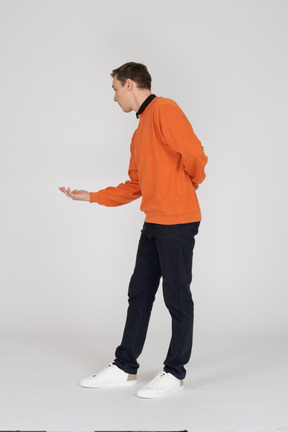 Junger mann im orangefarbenen sweatshirt stehend