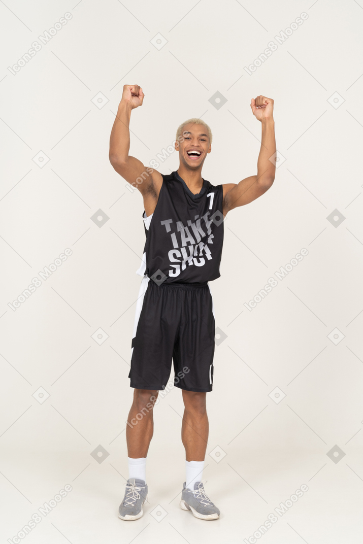Front view of a happy young male basketball player raising hands
