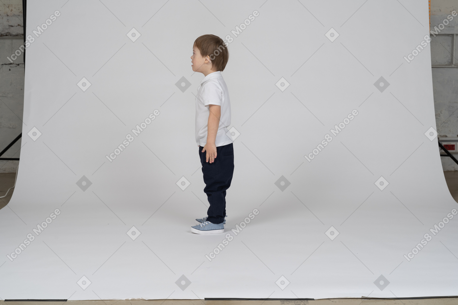 Little boy standing upright with arms at side