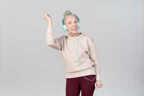 Joyful young lady in headphones dancing to music