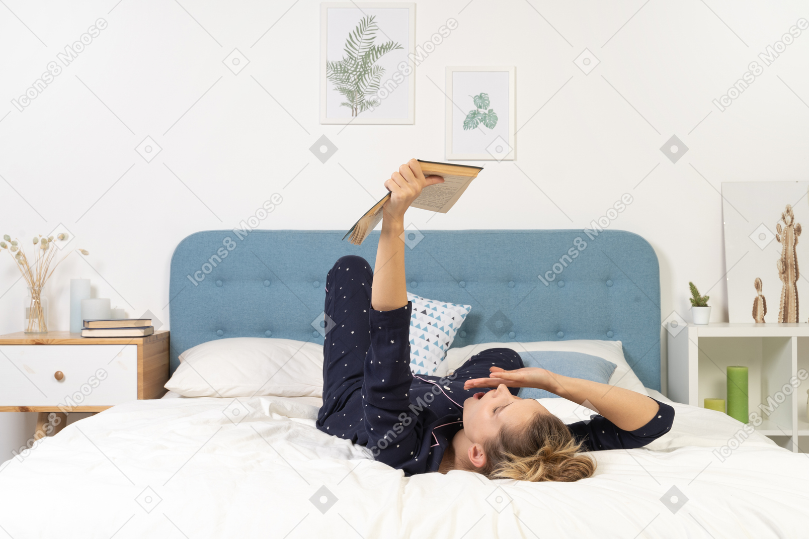 Full-length of a bored young lady trying to read book in bed