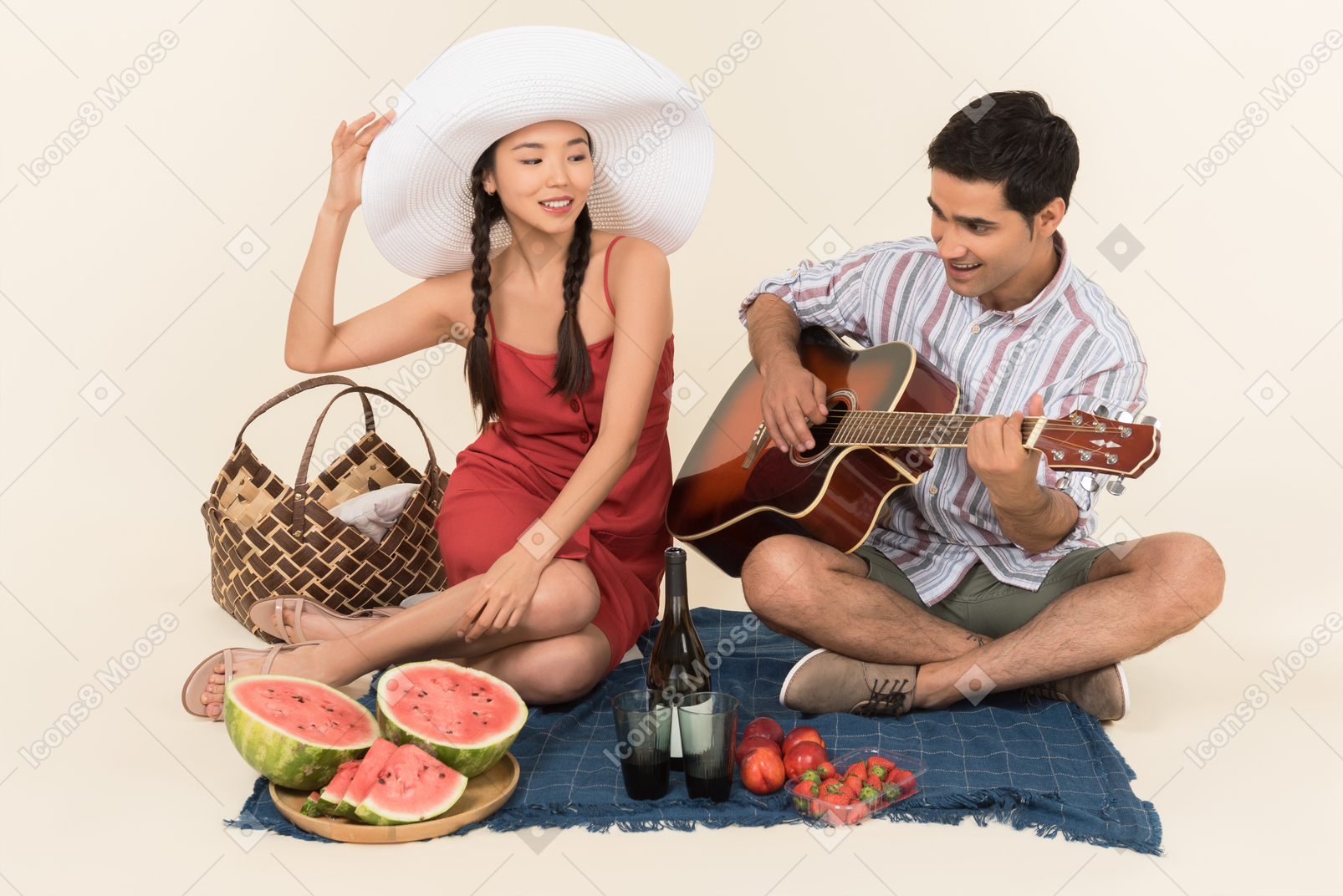 Pareja interracial haciendo picnic y hombre tocando la guitarra