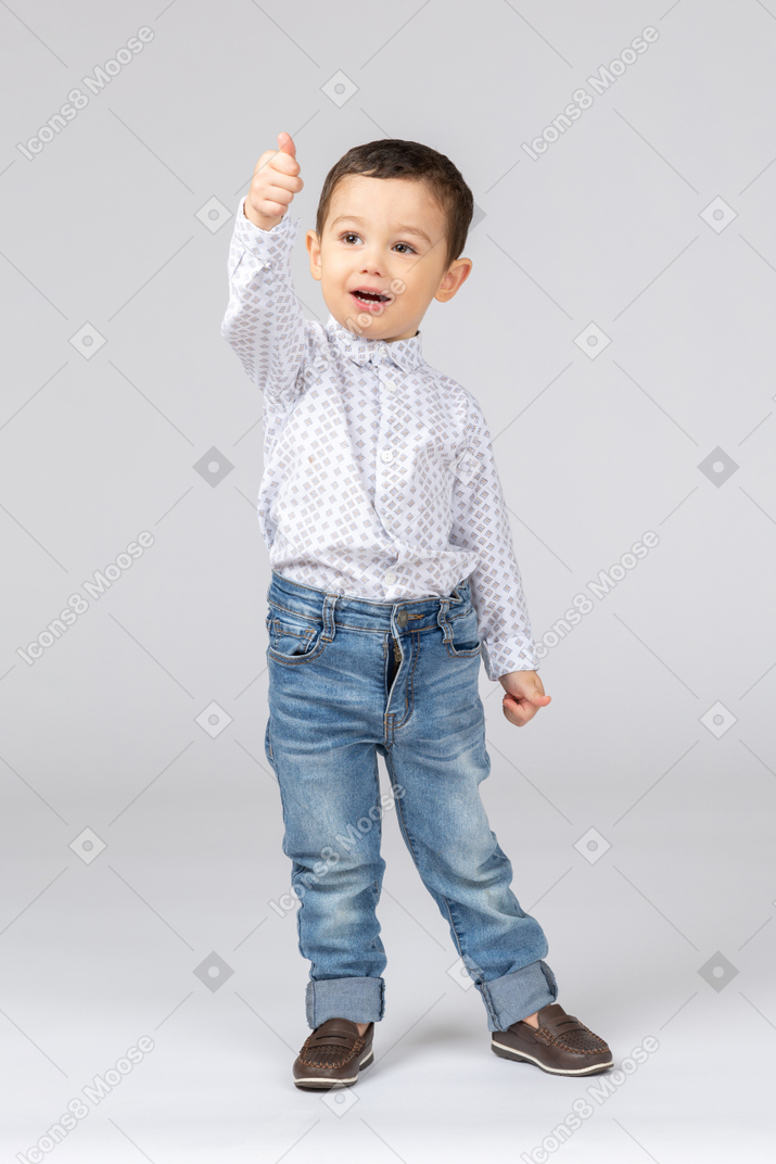 Um garotinho mostrando os polegares