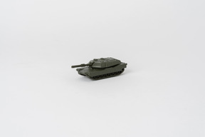 A side shot of a toy tank standing against a plain white background
