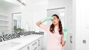 Femme fatiguée de nettoyer la salle de bain